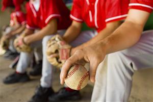 Players in dugout holding a ball